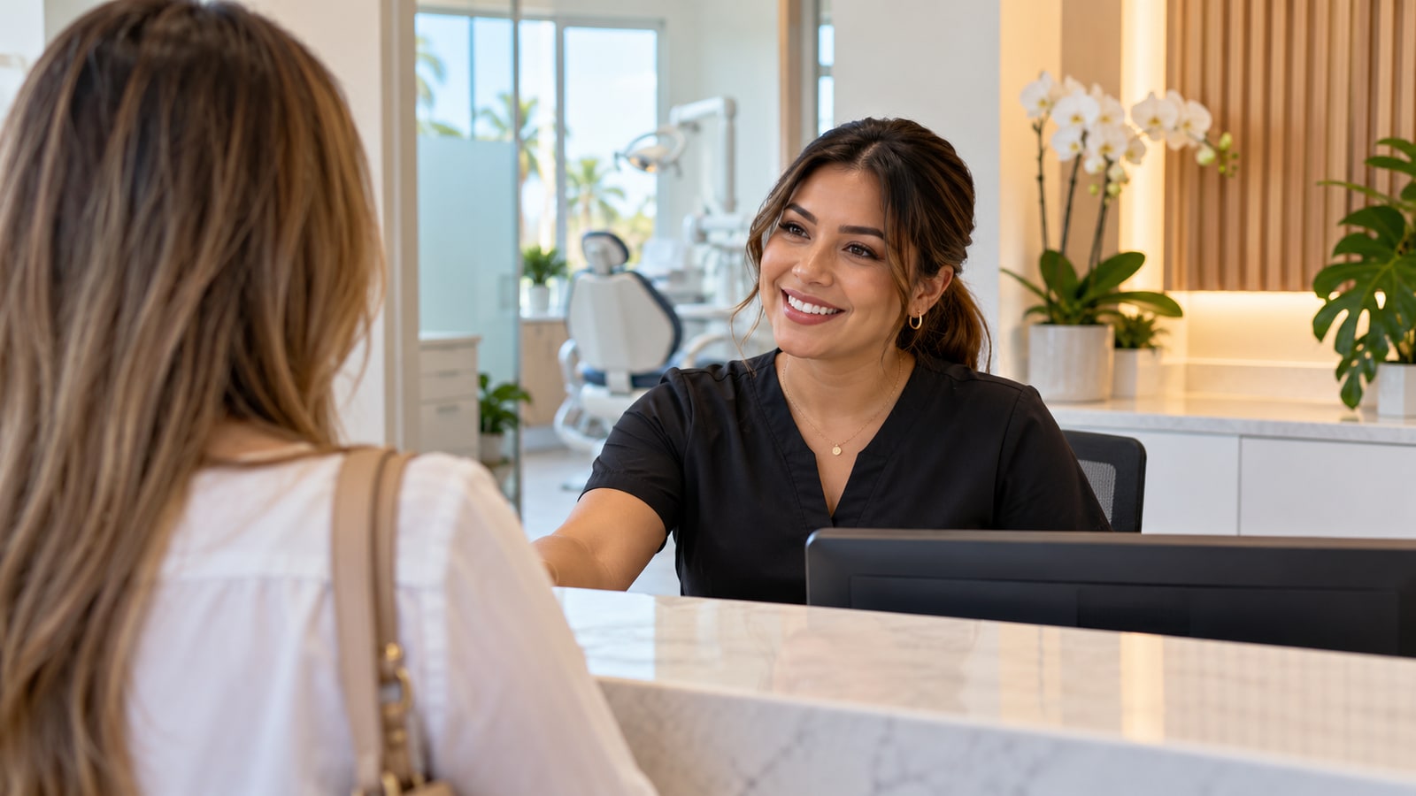 Dental office receptionist welcoming a patient at the front desk